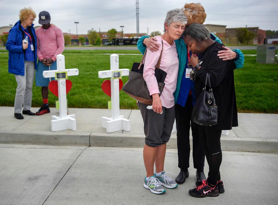 Members of the Billy Graham Rescue Response Team pray with Lancelot DeSilva, second left, Susan Cox, third from right, and Valerie Aaron, right, at a memorial outside the Antioch Waffle House for the four people killed by a gunman on April 25, 2018.