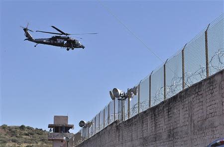 A Federal Police Black Hawk helicopter flies over the Tuxpan prison in Iguala, in the Mexican State of Guerrero January 3, 2014. REUTERS/Jesus Solano