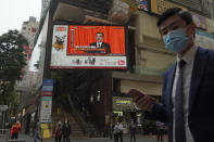 A TV screen broadcasts the news of the opening session of China's National People's Congress (NPC), in Hong Kong, Friday, March 5, 2021. A senior Chinese official says the largely pro-Beijing committee that currently elects the Hong Kong's leader will also elect some members of the city's legislature, as part of Beijing's planned revamp of Hong Kong's electoral system. (AP Photo/Kin Cheung)