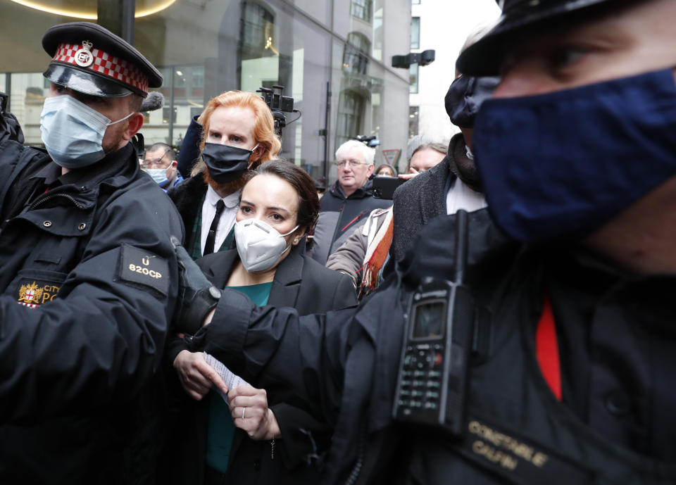 Stella Moris, center left, girlfriend of Julian Assange, is escorted by police after speaking to the media after a ruling that he cannot be extradited to the United States, outside the Old Bailey in London, Monday, Jan. 4, 2021. A British judge has rejected the United States' request to extradite WikiLeaks founder Julian Assange to face espionage charges, saying it would be "oppressive" because of his mental health. District Judge Vanessa Baraitser said Assange was likely to commit suicide if sent to the U.S. The U.S. government said it would appeal the decision. (AP Photo/Frank Augstein)