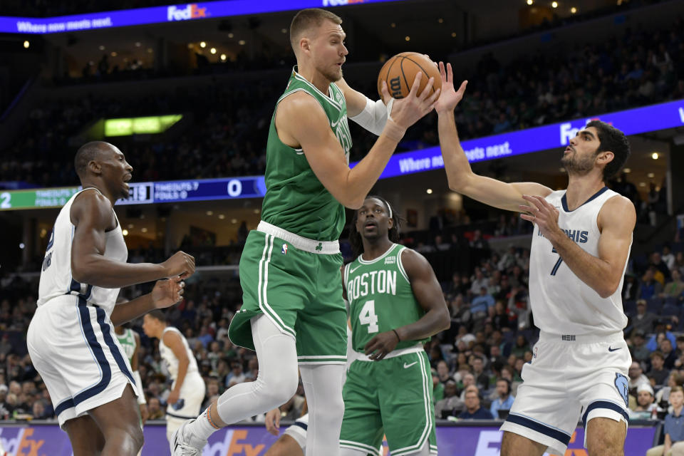 Boston Celtics center Kristaps Porzingis, handles the ball against Memphis Grizzlies forward Santi Aldama (7) in the first half of an NBA basketball game Sunday, Nov. 19, 2023, in Memphis, Tenn. (AP Photo/Brandon Dill)