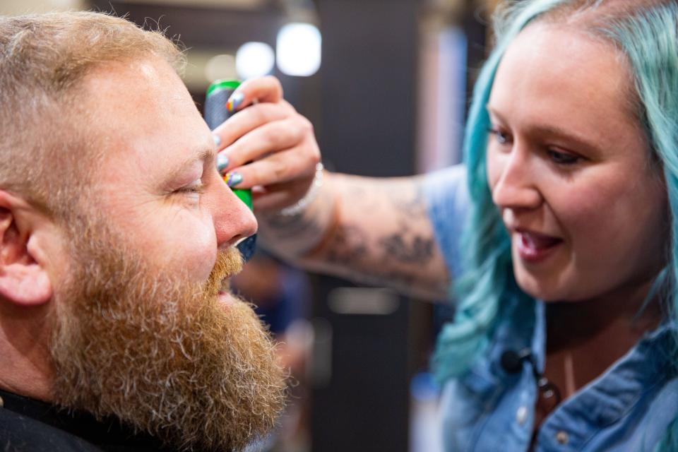 Thor Hanson gets a free haircut, beard trim, and facial from cosmetologist Jeanie Stark as a fathers day gift at Scissors and Scotch in Ankeny, Thursday, June 16, 2022.