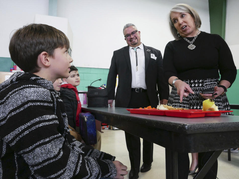 New Mexico Gov. Michelle Lujan Grisham, right, speaks to students at an elementary school in Santa Fe, N.M., Monday, March 27, 2023. The governor visited the school and signed legislation to provide free breakfast and lunch to all New Mexico students. (Matt Dahlseid/Santa Fe New Mexican via AP)