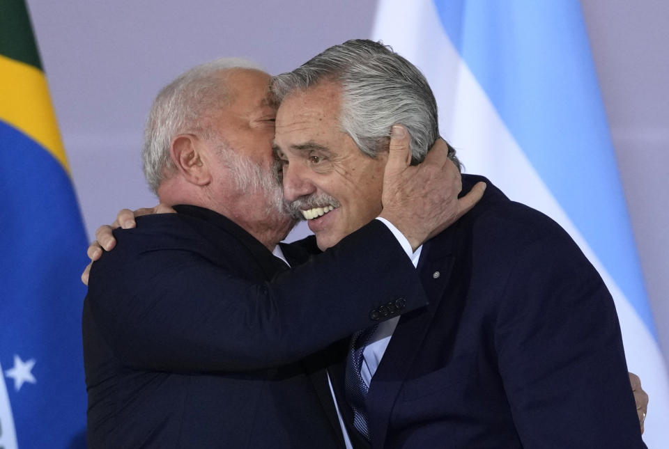 Brazil's President Luiz Inacio Lula da Silva, left, whispers into the ear of Argentina's President Alberto Fernandez, as they assemble for a group photo during the South American Summit at Itamaraty palace in Brasilia, Brazil, Tuesday, May 30, 2023. South America's leaders are gathering as part of Lula's attempt to reinvigorate regional integration efforts. (AP Photo/Andre Penner)