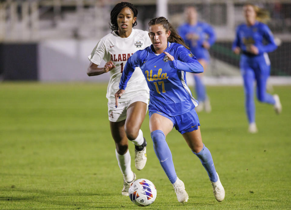 UCLA's Lexi Wright (17) works with the ball in front of Alabama's Gianna Paul during the first half of an NCAA women's soccer tournament semifinal in Cary, N.C., Friday, Dec. 2, 2022. (AP Photo/Ben McKeown)