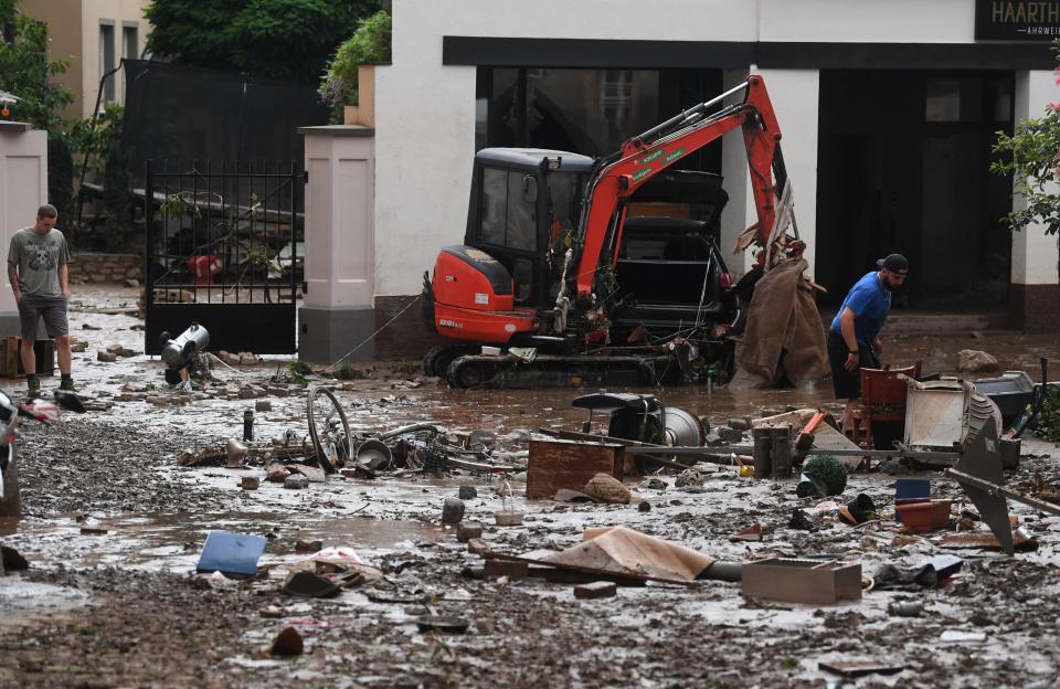 Residents look at debris in the muddy streets, following flood waters in a street in the town of Ahrweiler-Bad Neuenahr, western Germany, on July 15, 2021. - Heavy rains and floods lashing western Europe have killed at least 45 people in Germany and left around 50 missing, as rising waters led several houses to collapse. (Photo by Christof STACHE / AFP) (Photo by CHRISTOF STACHE/AFP via Getty Images)