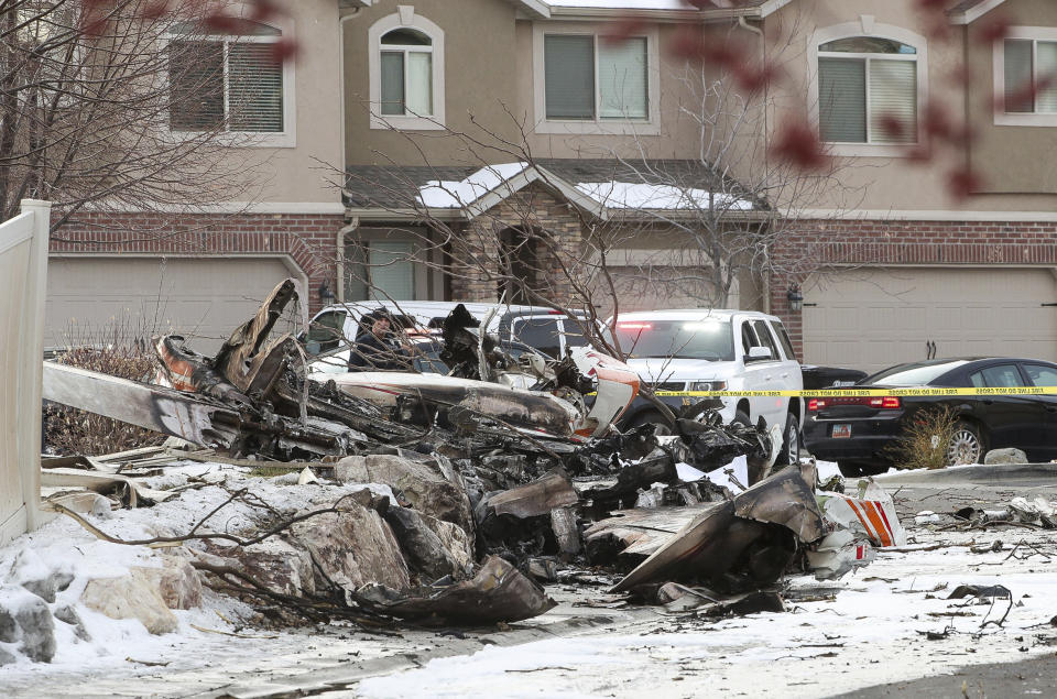 This photo shows debris from a small private plane that crashed in a residential area in Roy, Utah, Wednesday, Jan. 15, 2020. The small plane crashed Wednesday, killing the pilot as the aircraft narrowly avoided hitting any townhomes, authorities said. (Steve Griffin/The Deseret News via AP)