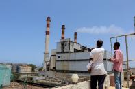 Workers stand at the yard of the state-owned al-Haswa power station in Aden