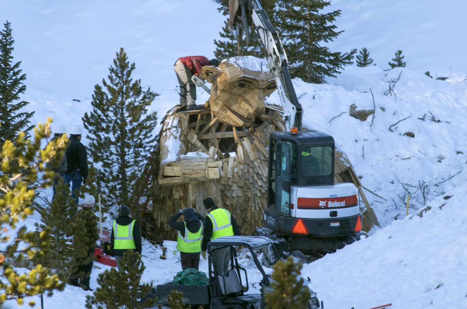 Thursday morning, Nov. 15, 2018, the Town of Breckenridge employees beheads "Isak Hearthstone," a wooden troll built by artist Thomas Dambo, by a chainsaw to remove it entirely from the Wellington Trail, in Breckenridge, Colo. The troll was created during the Breckenridge Festival of the Arts in August, but got so popular that it caused complaints from nearby homeowners due to tourists visiting, and demanded it to be removed. (Hugh Carey/Summit Daily News via AP)