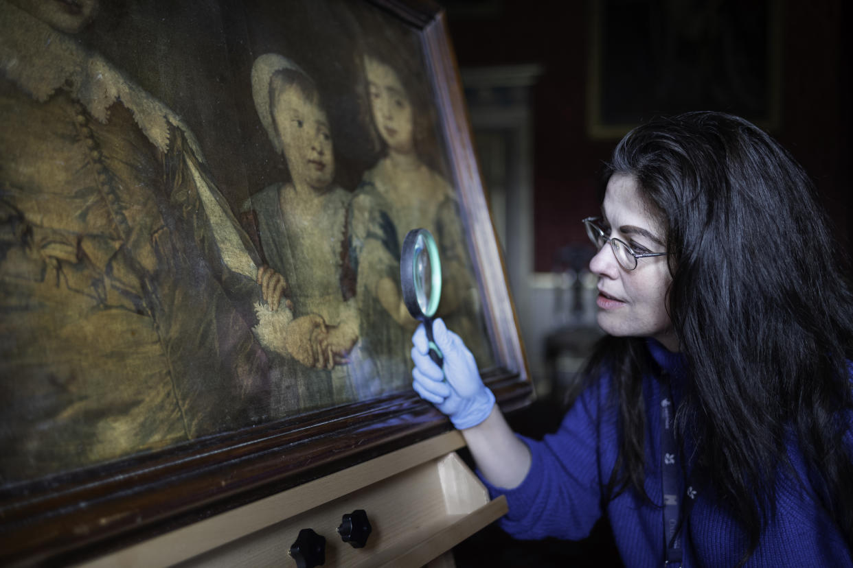 A curator inspects the recently discovered print by the 18th Century printmaker Jacob Christoff Le Blon at Oxburgh Hall in Norfolk. (Mike Hodgson/ National Trust/ PA)