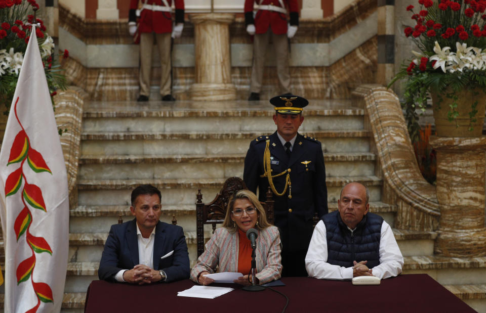 Bolivia's interim President Jeanine Anez, center, speaks during a press conference at the presidential palace, in La Paz, Bolivia, Thursday, Nov. 28, 2019. Accompanied by his Ministry of Defense Luis Fernando Lopez, left, and Government Minister Arturo Murillo, Anez reported today that she has determined to repeal Decree 4078, which authorized the military to participate in public restoration operations without having criminal responsibility for the use of force in situations of need and defense. (AP Photo/Juan Karita)