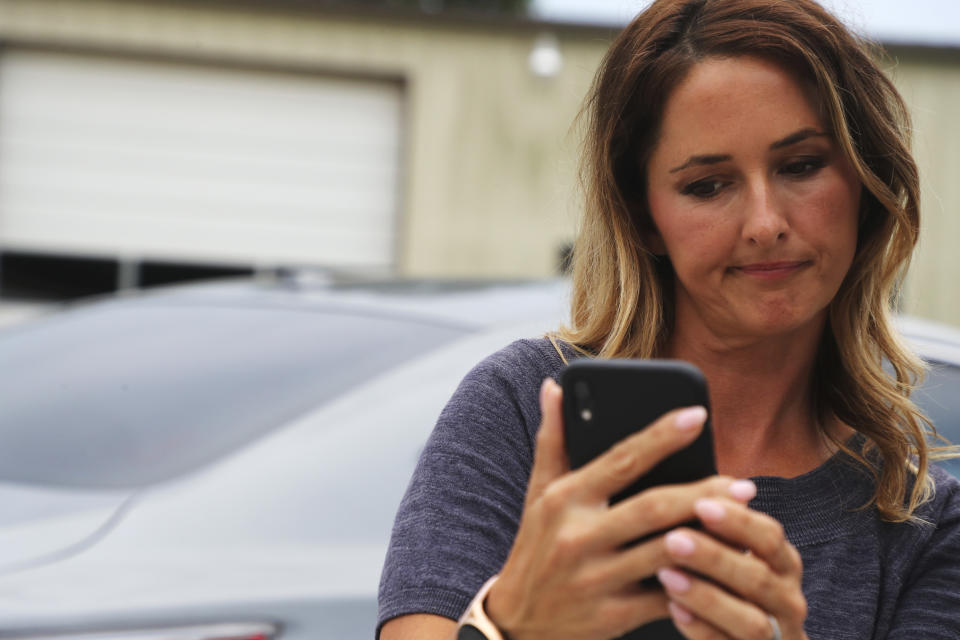 Roxanne Ward views cell phone video she took of the commotion following a crash-landing in a field near Ripley, Miss., on Saturday, Sept. 3, 2022. Authorities say a man who stole a plane and flew it over Mississippi after threatening to crash it into a Walmart store faces charges of grand larceny and terroristic threats. Tupelo Police Chief John Quaka said Cory Wayne Patterson didn't have a pilot's license but had some flight instruction and was an employee of Tupelo Aviation. (AP Photo/Nikki Boertman)