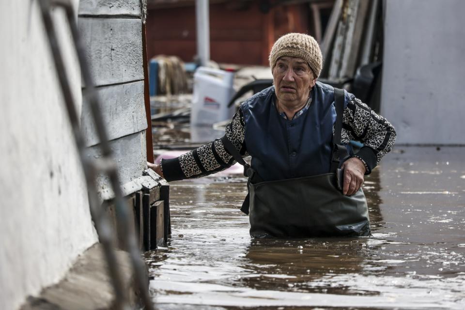 A woman walks near her house in a flooded area in Orenburg, Russia, Wednesday, April 10, 2024. Russian officials are scrambling to help homeowners displaced by floods, as water levels have risen in the Ural River. The floods in the Orenburg region near Russia's border with Kazakhstan sparked the evacuation of thousands of people following the collapse of a dam on Saturday. (AP Photo)