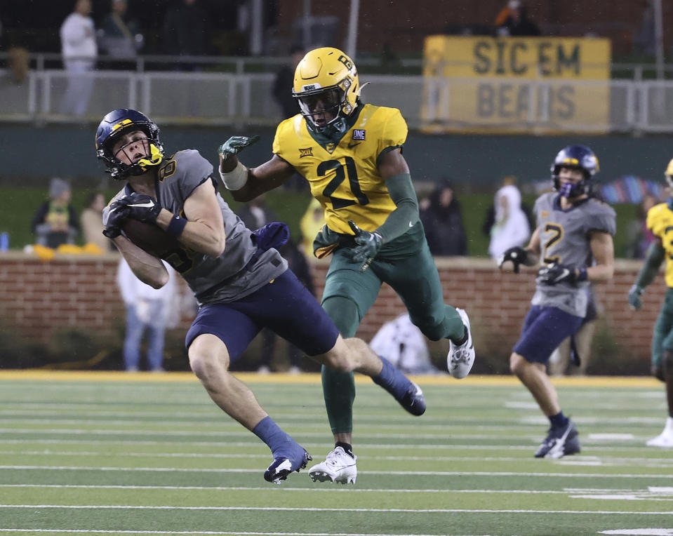 West Virginia wide receiver Hudson Clement, left, catches a pass over Baylor cornerback Chateau Reed (21) in the first half of an NCAA college football game, Saturday, Nov. 25, 2023, in Waco, Texas. (Jerry Larson/Waco Tribune-Herald, via AP)