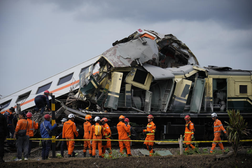 Rescuers inspect the wreckage after the collision between two trains in Cicalengka, West Java, Indonesia, Friday, Jan. 5, 2024. The trains collided on Indonesia's main island of Java on Friday, causing several carriages to buckle and overturn, officials said. (AP Photo/Achmad Ibrahim)