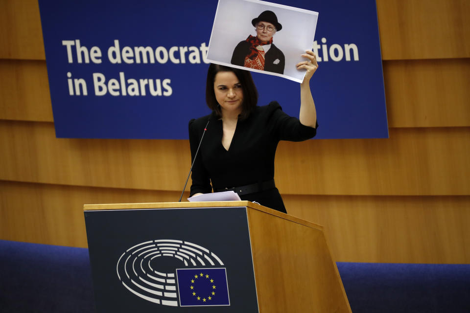 Belarusian opposition politician Sviatlana Tsikhanouskaya holds a picture of Belarusian opposition activist Nina Baginskaya as she gives a speech during the Sakharov Prize ceremony at the European Parliament in Brussels, Wednesday, Dec. 16, 2020. The European Union has awarded its top human rights prize to the Belarusian democratic opposition. (AP Photo/Francisco Seco)