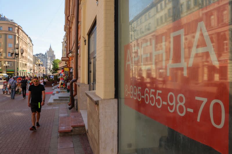 FILE PHOTO: A pedestrian walks past the windows of business premises put out for rent in Moscow