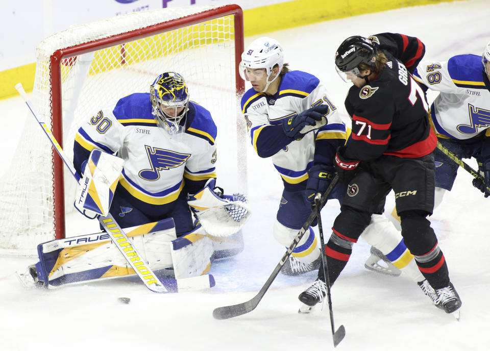 Ottawa Senators' Ridly Greig (71) tries to score on St. Louis Blues goaltender Joel Hofer (30) as Blues' Matthew Kessel (51) tries to block him during the first period of an NHL hockey game in Ottawa, Ontario, on Thursday, March 21, 2024. (Patrick Doyle/The Canadian Press via AP)