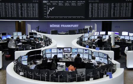 Traders are pictured at their desks in front of the German share price index DAX board at the Frankfurt stock exchange November 18, 2014. REUTERS/Remote/Stringer