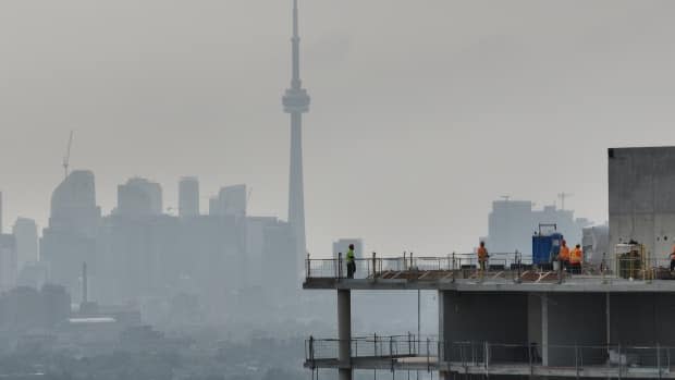 Construction workers go about their business against a smoky Toronto skyline on June 28, 2023. The University of Toronto said that day that the city had some of the worst air quality in the world as smoke from wildfires in northeastern Ontario and Quebec moved into the city. 