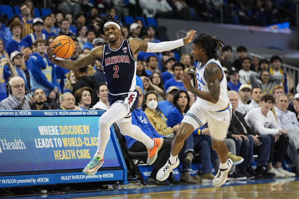 Arizona guard Caleb Love, left, grabs a loose ball against UCLA guard Dylan Andrews during the first half of an NCAA college basketball game in Los Angeles, Thursday, March 7, 2024. (AP Photo/Jae C. Hong)