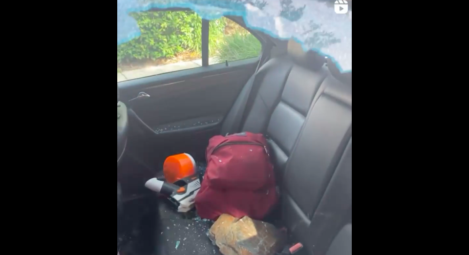 The rock that was thrown at the 16-year-old’s car is seen in the backseat of his car, surrounded by shards of glass from his broken window (Facebook/CJ Jones)