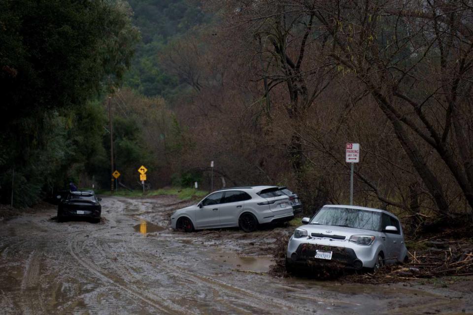 <p>Eric Thayer/Bloomberg via Getty</p> Vehicles along a mud-covered road during a storm in Malibu, California, US, on Monday, Feb. 5, 2024.