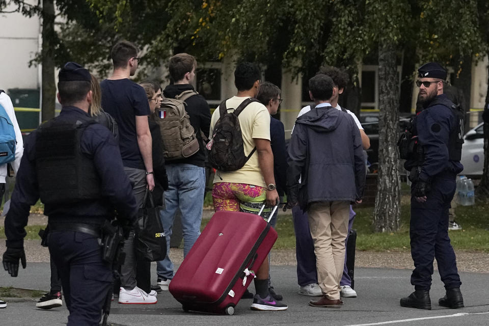 Schoolchildren leave the Gambetta high school after a man armed with a knife killed a teacher and wounded two others in Arras, northern France, Friday, Oct. 13, 2023. A man of Chechen origin who was under surveillance by the French security services over suspected radicalization stabbed a teacher to death at his former high school and critically wounded two other people in northern France. (AP Photo/Michel Euler)