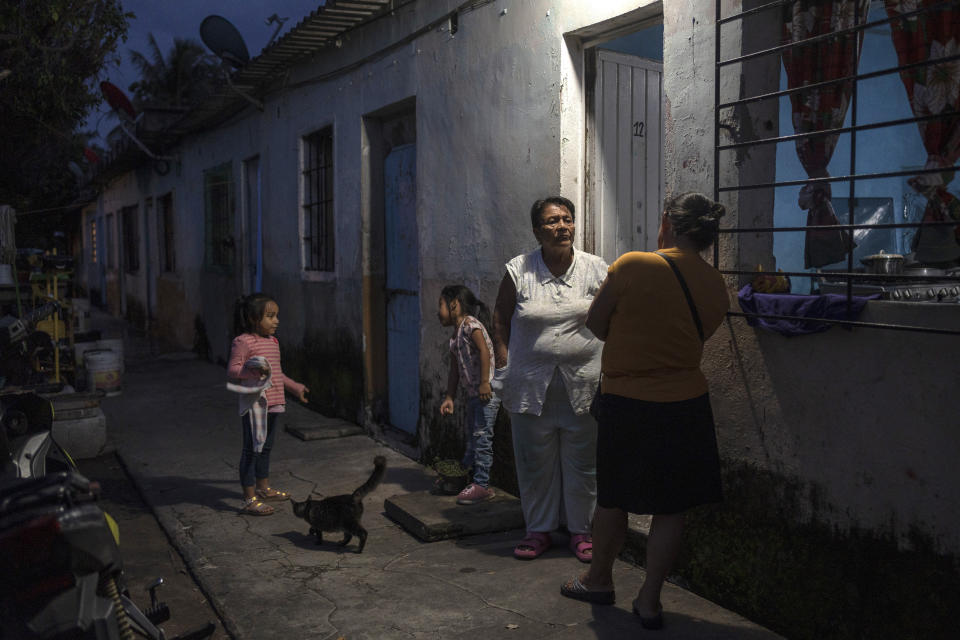 Climate refugee Eglisa Arias, center, talks with a family member outside the home she is renting, in Frontera, in the state of Tabasco, Mexico, Wednesday, Nov. 29, 2023. Arias was driven from her home when a fast moving sea-level rise destroyed her coastal community of El Bosque. (AP Photo/Felix Marquez)