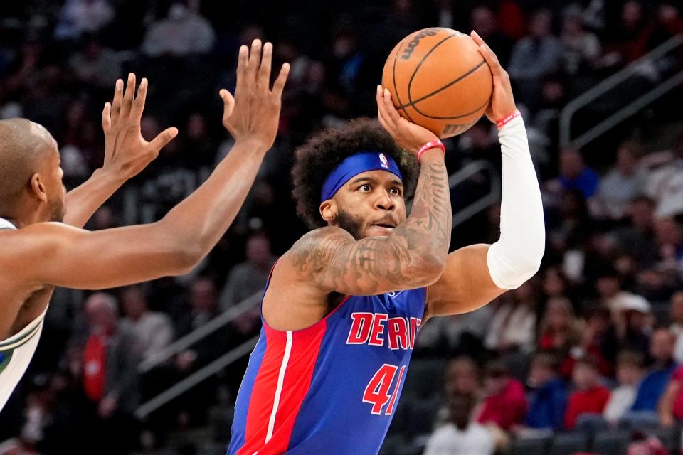 Detroit Pistons forward Saddiq Bey takes a shot against Milwaukee Bucks forward Khris Middleton during the first quarter at Little Caesars Arena, April 8, 2022.