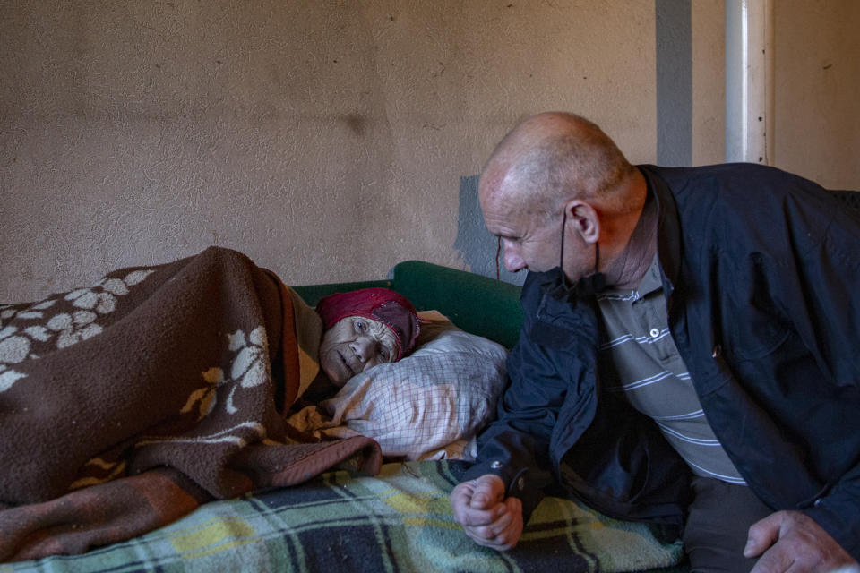 Kosovo Albanian Fadil Rama, right, speaks to a Kosovo Serb Blagica Dicic a lonely 92-year old woman in a remote village of Vaganesh, Kosovo on Thursday, Nov. 19, 2020. Blagica Dicic is in failing health, and is the only resident of a remote ethnic Serb minority village in the mountains of eastern Kosovo that’s been abandoned by all its other inhabitants, even her own children, but Fadil Rama, 54, comes from the other side of Kosovo’s bitter ethnic divide. (AP Photo/Visar Kryeziu)