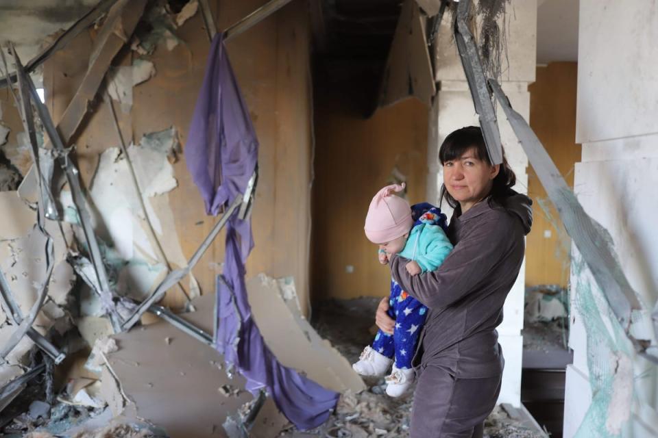 Olga Balan and her child at their bombed-out home (Tom Mutch)