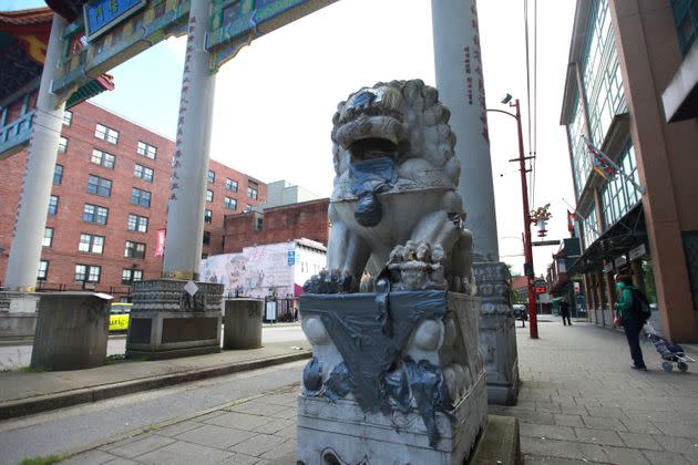 A statue is seen at the gates of Vancouver's Chinatown with racist graffiti covered, on May 21, 2020.