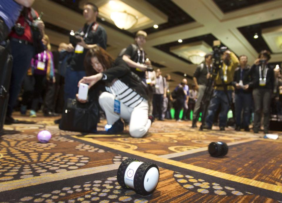 A woman takes a photo of a Sphero 2.0 by Orbotix during "CES Unveiled," a media preview event to the annual Consumer Electronics Show (CES), in Las Vegas, Nevada, January 5, 2014. The Sphero 2.0 and 2B (foreground) are controlled with a smartphone. The Sphero 2.0 is already available. The 2B expected to ship in the fall of 2014, a representative said. (REUTERS/Steve Marcus)