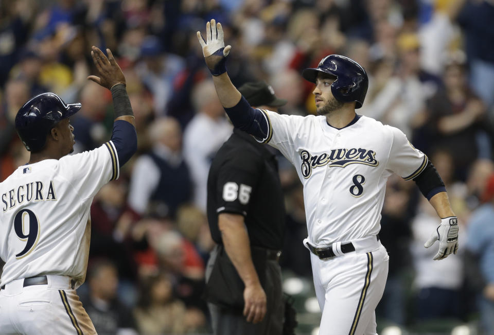 Milwaukee Brewers' Ryan Braun (8) and Jean Segura high-five after scoring on Aramis Ramirez's two-RBI double against the Atlanta Braves in the fourth inning of an opening day baseball game Monday, March 31, 2014, in Milwaukee. (AP Photo/Jeffrey Phelps)