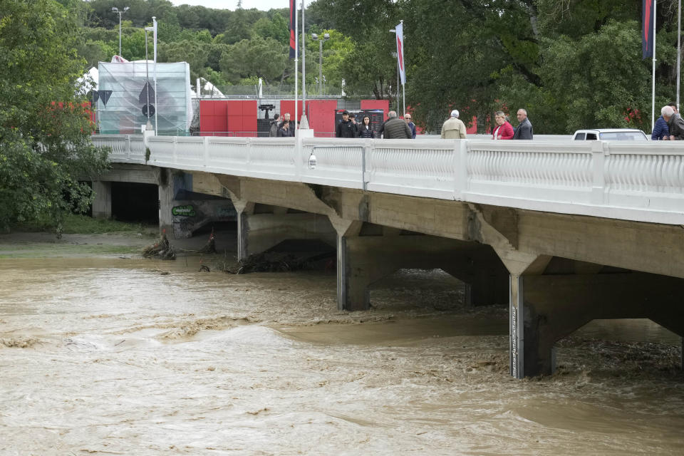 People look at the swollen Santerno River near the Enzo e Dino Ferrari circuit, in Imola, Italy, Wednesday, May 17, 2023. The weekend's Emilia-Romagna Grand Prix in Imola has been canceled because of deadly floods. Formula One said it made the decision for safety reasons and to avoid any extra burden on the emergency services. F1 personnel had earlier been told to stay away from the track after floods affected large parts of the Emilia-Romagna region. (AP Photo/Luca Bruno)