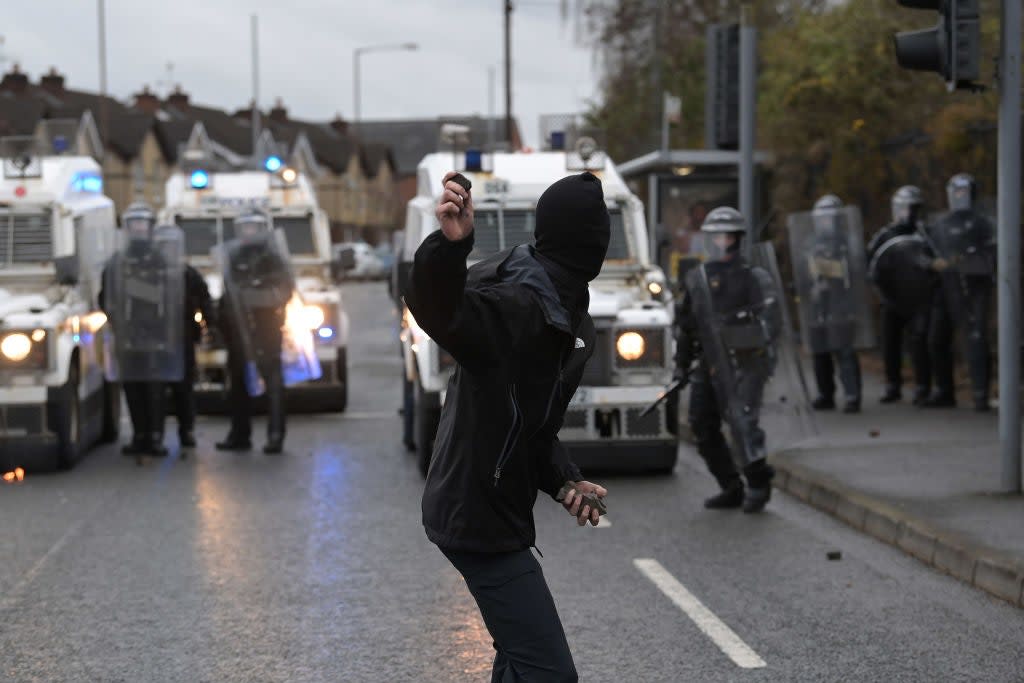 <p>A nationalist attacks police on Springfield Road, near the Peace Wall gates dividing nationalist and loyalist communities, on 8 April</p> (Getty Images)