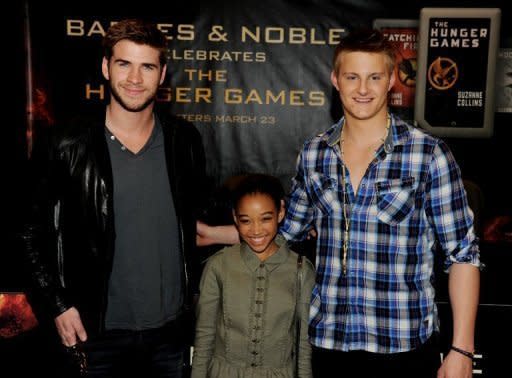 (L-R) Actors Liam Hemsworth, Amandla Stenberg and Alexander Ludwig of Lionsgate's "The Hunger Games" pose at Barnes & Noble at The Grove on March 22 in Los Angeles, California. "The Hunger Games," a sci-fi action film about a teenage girl fighting to survive a life-and-death game show in a dystopian world, broke records Sunday to become the first blockbuster movie of 2012