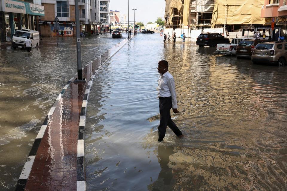 A man walks in the floodwater in the UAE, which experts are divided on as to whether it was caused by ‘cloud seeding’ (REUTERS)