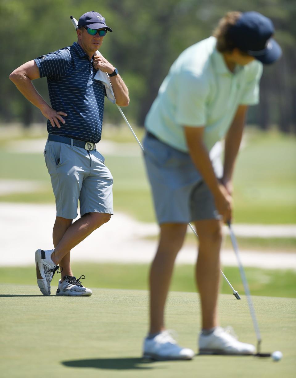 University of North Florida men's golf coach Scott Schroeder (background) has guided the Ospreys to seven ASUN Championships and 14 appearances in the NCAA Tournament.