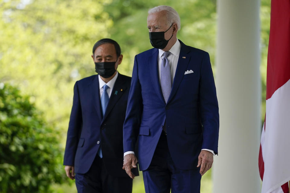 President Joe Biden, accompanied by Japanese Prime Minister Yoshihide Suga, walks from the Oval Office to speak at a news conference in the Rose Garden of the White House, Friday, April 16, 2021, in Washington. (AP Photo/Andrew Harnik)