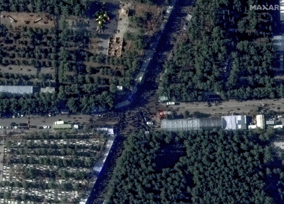 This image, provided by Maxar Technologies, shows people along a road near the martyr's cemetery in Kerman, Iran Wednesday, Jan. 3, 2024 before, according to Iranian authorities, twin bomb blasts killed at least 103 people at an event honoring a prominent Iranian general slain in a U.S. airstrike in 2020. (Satellite image ©2023 Maxar Technologies via AP)