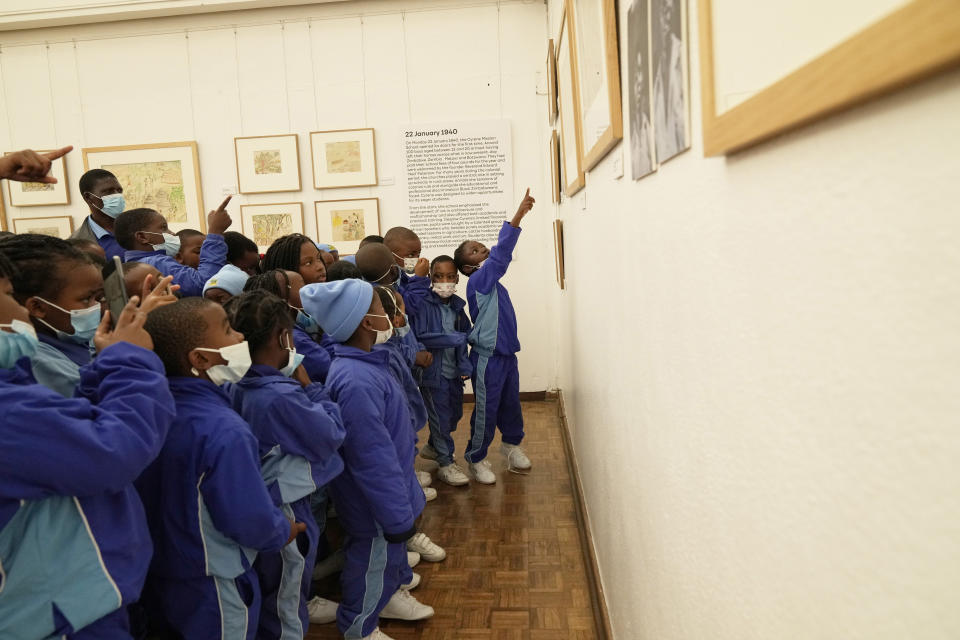 Schoolchildren look at paintings done in the 1940s and 1950s by young Black students at Cyrene Mission School at the National Gallery of Zimbabwe, Wednesday Aug. 3, 2022. The paintings are part of a historic exhibit, "The Stars are Bright," now showing in Zimbabwe for the first time since the collection left the country more than 70 years ago. (AP Photo/Tsvangirayi Mukwazhi)