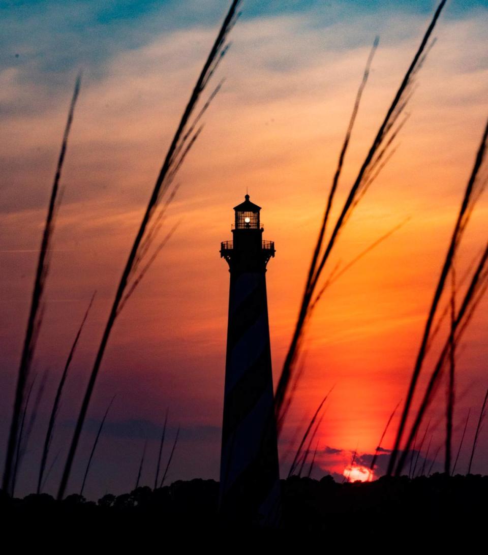 The sun sets behind the Cape Hatteras Light Station in Buxton Thursday, May 19, 2022.