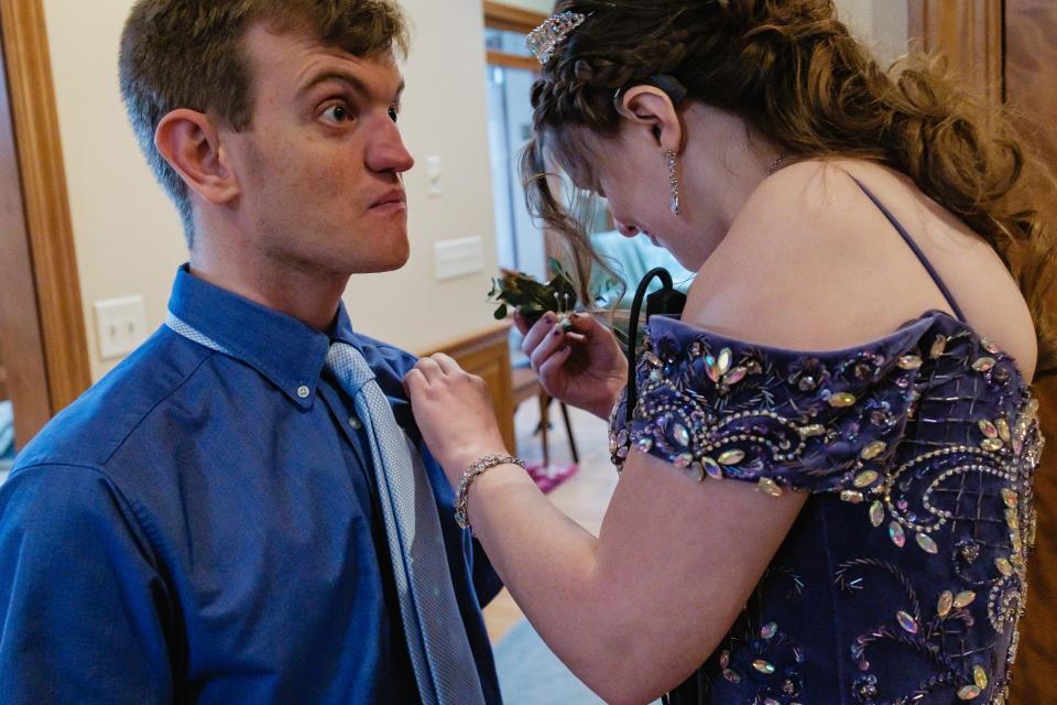 Kaylee Arthurs pins a boutonnière on Alec Worth before attending the Night to Shine dance in Canton.