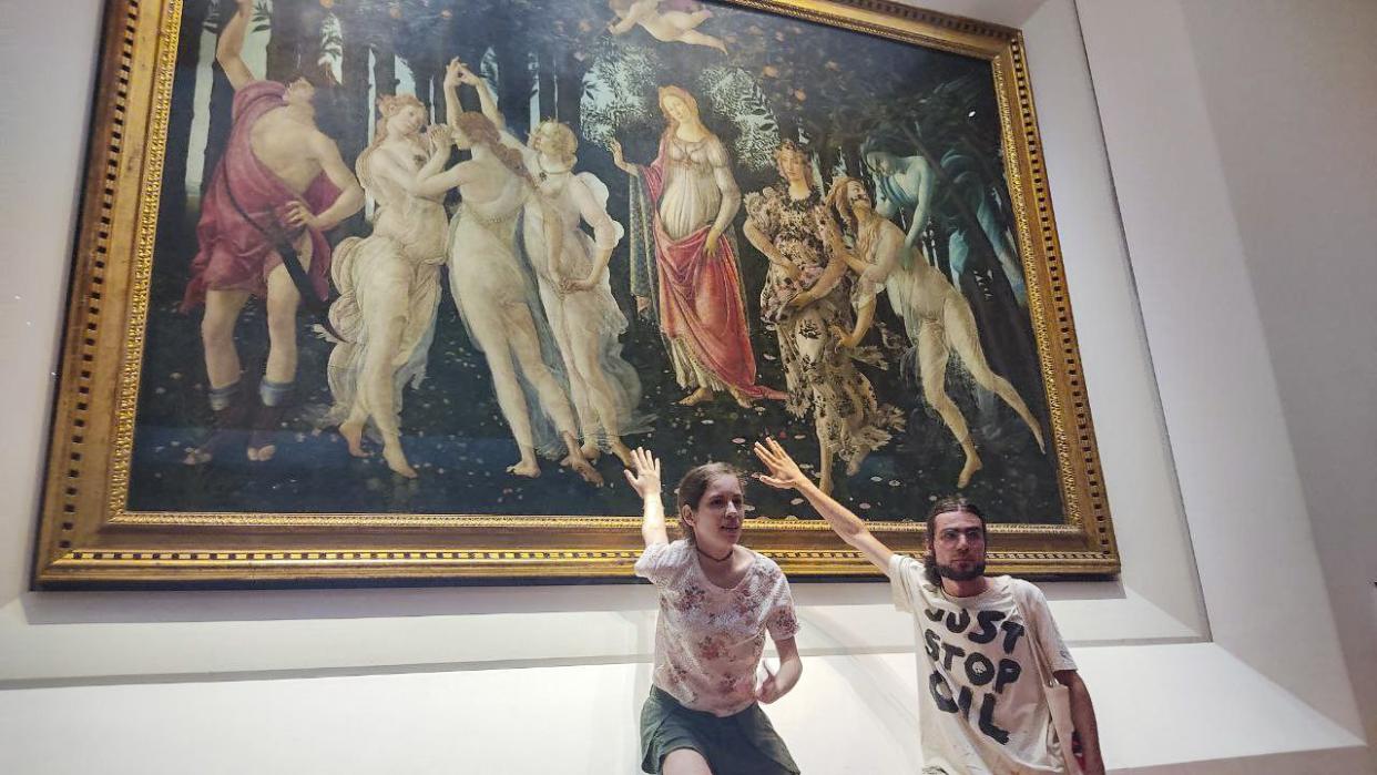 Two activists of Ultima Generazione (Last Generation) environmentalist group claim to glue themselves to the glass protecting Italian Renaissance painter Sandro Botticelli's Primavera (Spring) in Florence's Uffizi Galleries, central Italy, Friday.