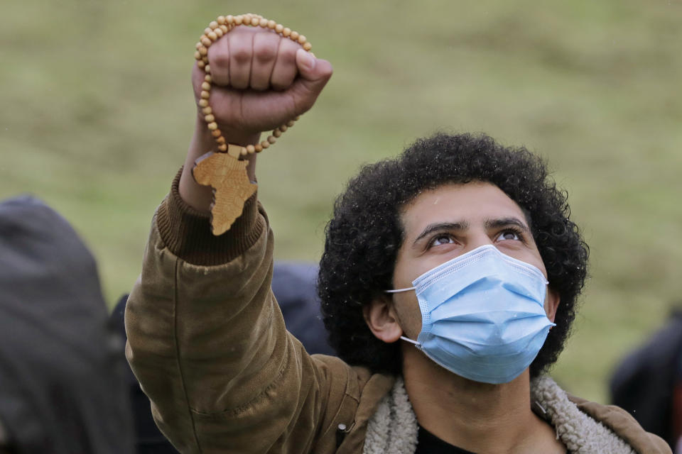 A man who declined to give his name holds up a necklace with a wood-cut of Africa on it as he takes part in a rally following a "Silent March" against racial inequality and police brutality that was organized by Black Lives Matter Seattle-King County, Friday, June 12, 2020, in Seattle. Hundreds of people marched for nearly two miles to support Black lives, oppose racism and to call for police reforms among other issues. (AP Photo/Ted S. Warren)
