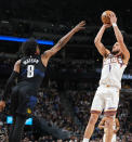 Phoenix Suns guard Devin Booker, right, goes up for a basket over Denver Nuggets forward Peyton Watson during the first half of an NBA basketball game Wednesday, March 27, 2024, in Denver. (AP Photo/David Zalubowski)