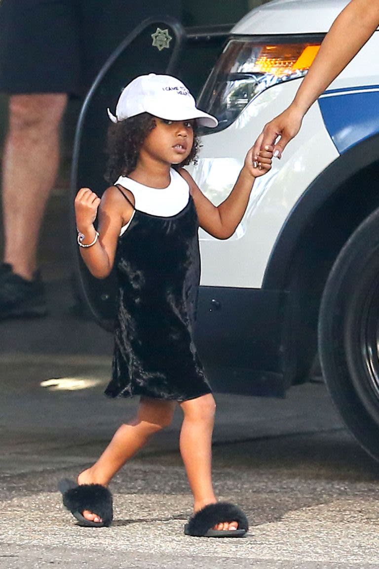 <p>North’s favorite look: the slip dress. Here she rocks the crushed velvet dress over a white tank, matching perfectly with her baseball cap. She also wears the Akid Troll Aston slides, which for a time were completely sold out — could that have been because of North? (Photo: Splash) </p>