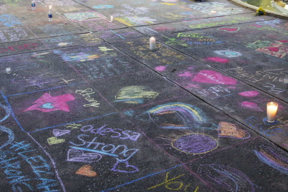 A sidewalk is filled with chalk messages following a prayer service, Sunday, Sept. 1, 2019, in Odessa, Texas, for the victims of a shooting spree the day before. (AP Photo/Sue Ogrocki)